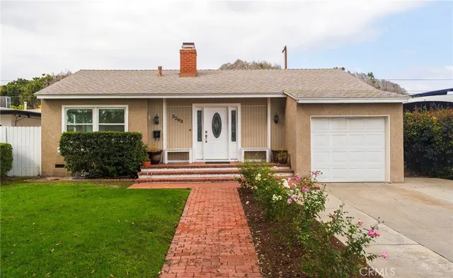 a front view of a house with a garden