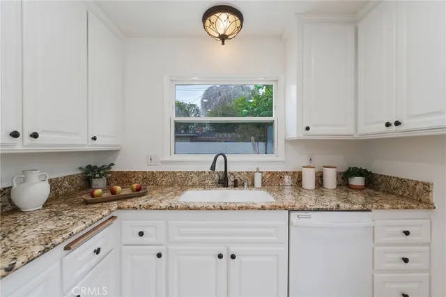 a kitchen with granite countertop a sink stainless steel appliances and cabinets