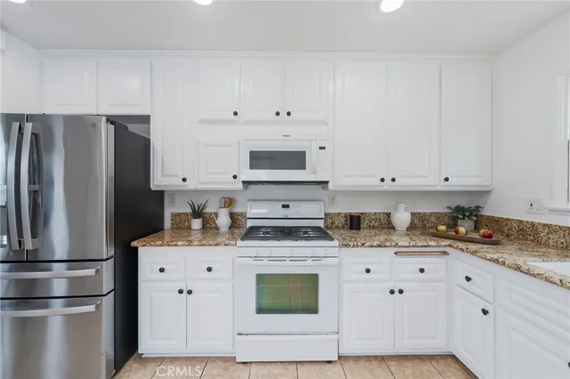 a kitchen with stainless steel appliances granite countertop a refrigerator sink and cabinets
