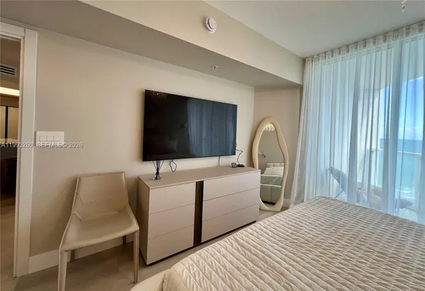 a bedroom with a bed and a flat screen tv