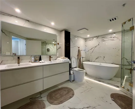 a bathroom with a tub sink shower and mirror