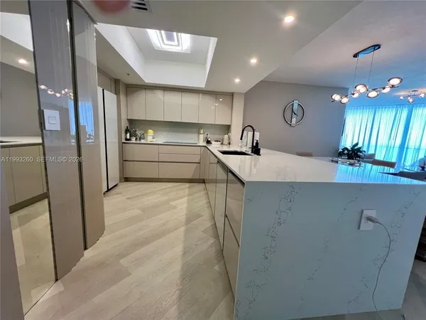 a large kitchen with a sink stainless steel appliances and cabinets