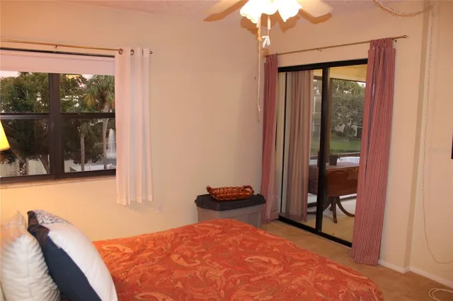 a bedroom with a bed and large window with balcony view