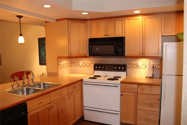 a kitchen with appliances a sink and cabinets