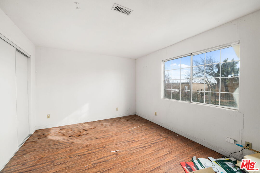 6906 Phelan Road Phelan, CA 92371 - Photo 18 of 42 an empty room with wooden floor and windows