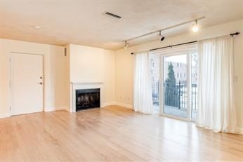 a view of an empty room with a fireplace and a window