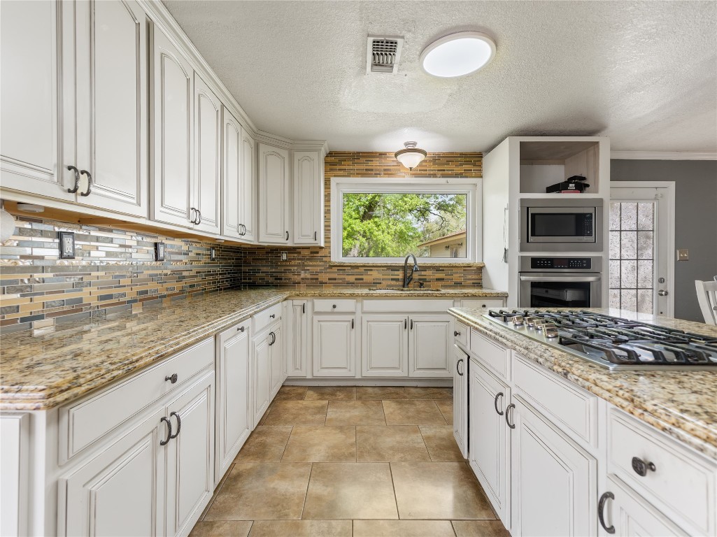 496 James Street Clute, TX 77531 - Photo 12 of 45 a kitchen with stainless steel appliances granite countertop a stove sink and cabinets