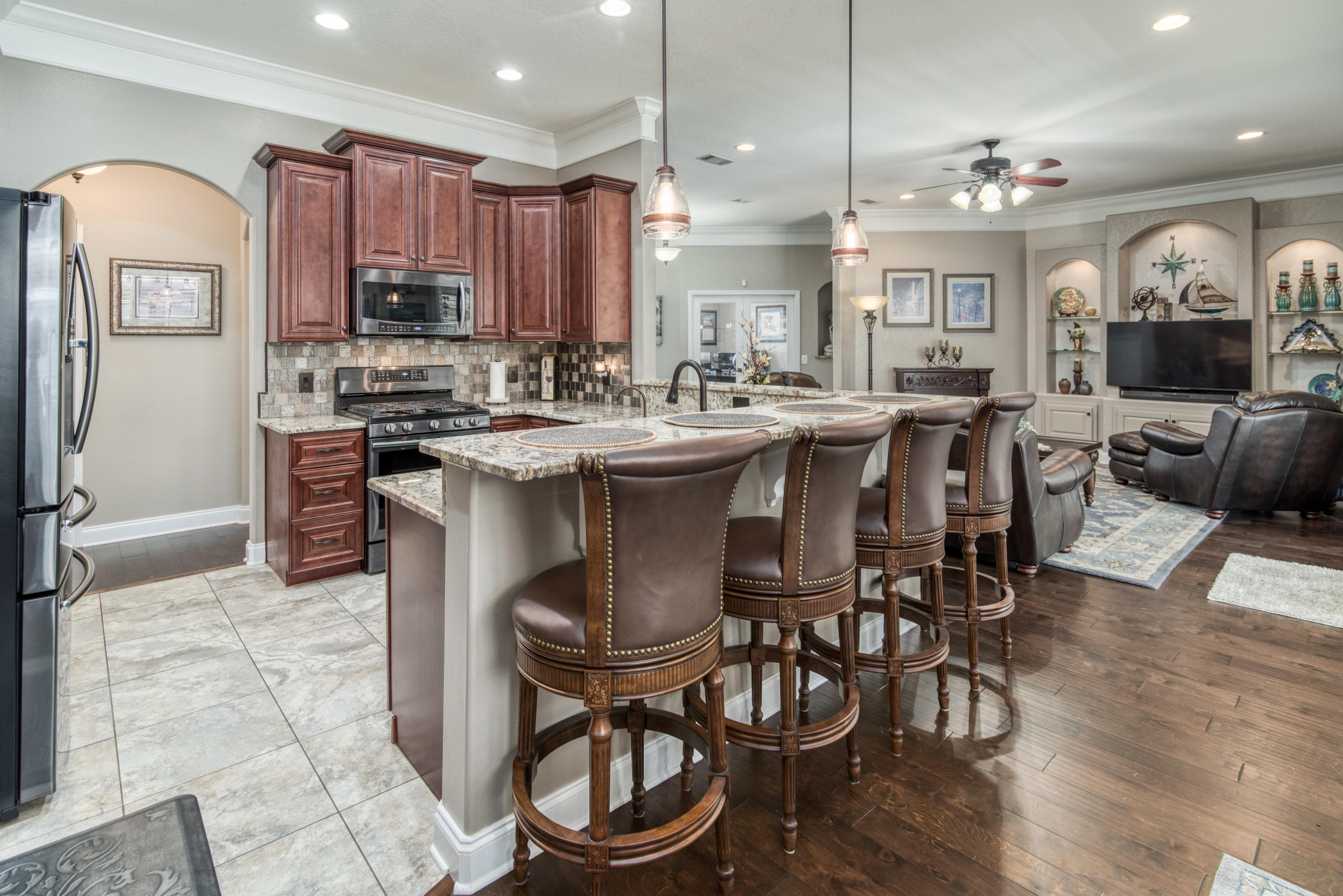 4563 Pfitzer Circle Crestview, FL 32536 - Photo 20 of 79 a kitchen with stainless steel appliances a stove a sink a oven a dining table and chairs with wooden floor