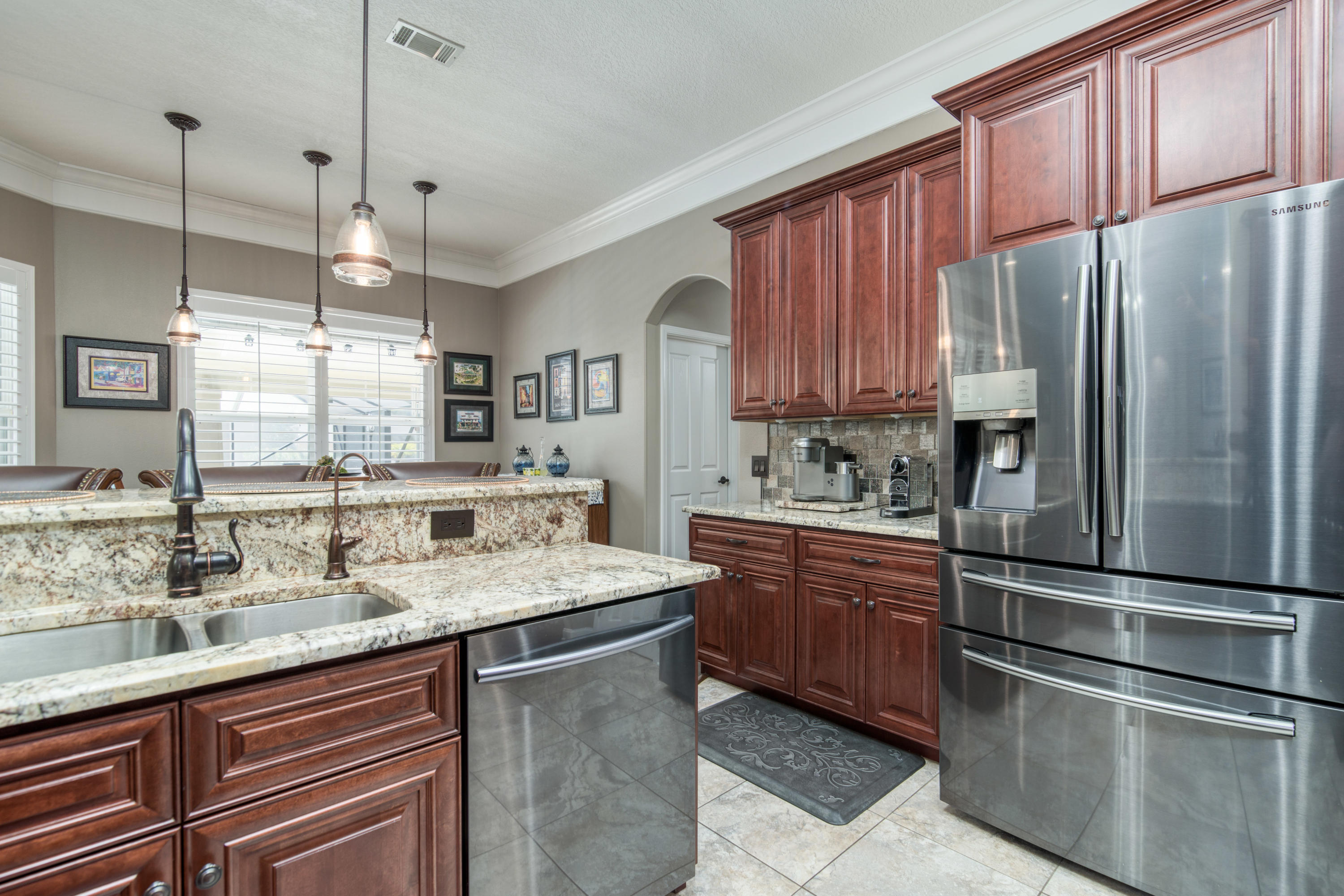 4563 Pfitzer Circle Crestview, FL 32536 - Photo 23 of 79 a kitchen with stainless steel appliances granite countertop a refrigerator a sink dishwasher a stove with wooden cabinets and floor