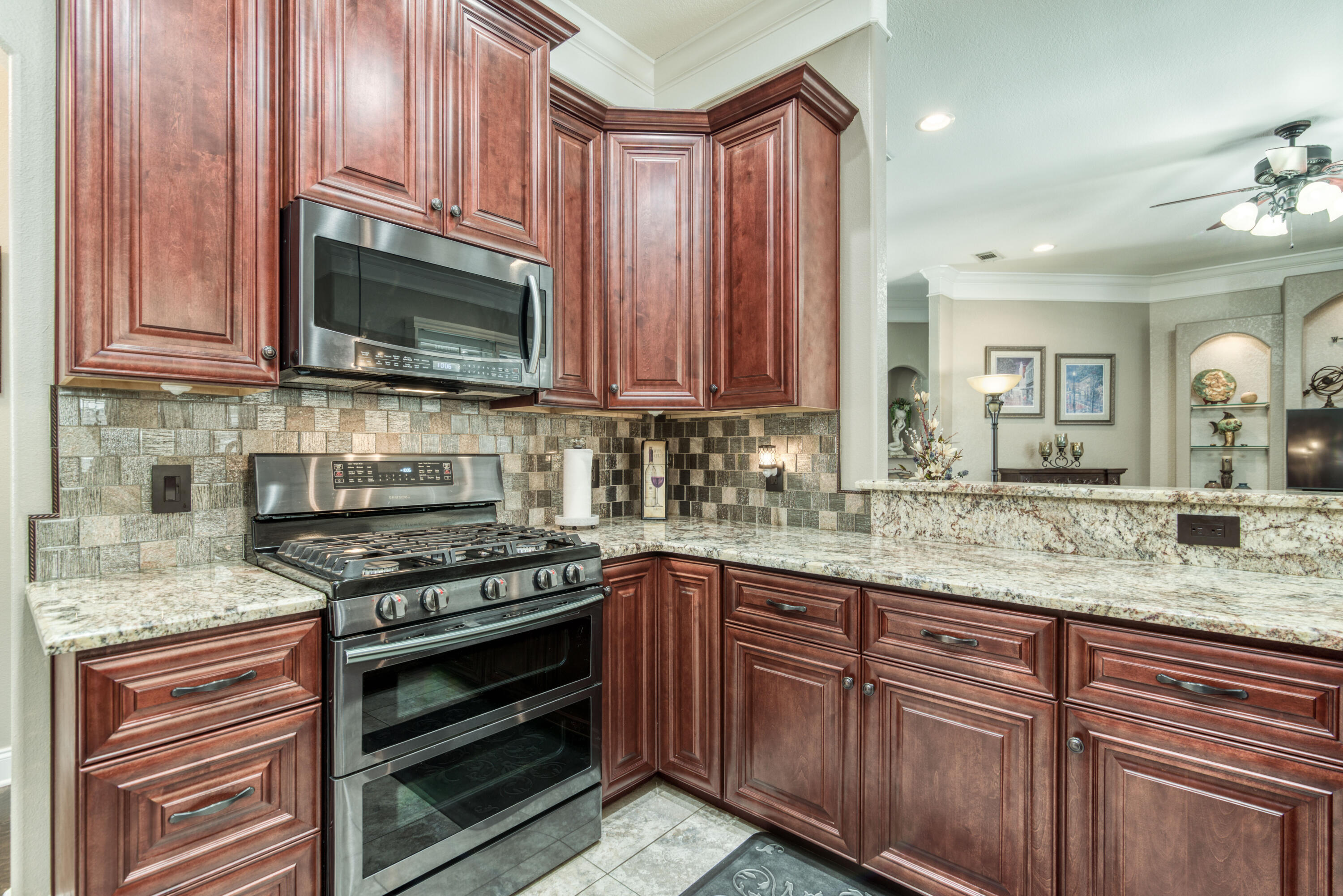 4563 Pfitzer Circle Crestview, FL 32536 - Photo 24 of 79 a kitchen with stainless steel appliances granite countertop a stove microwave and cabinets