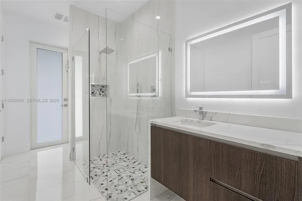 a bathroom with a granite countertop sink a shower and a mirror