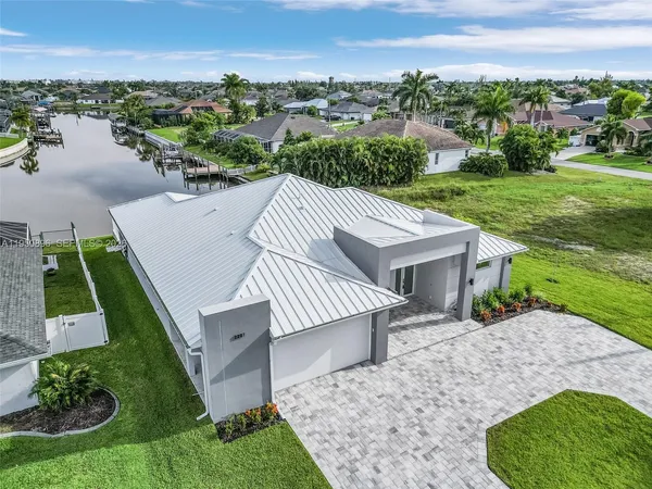 an aerial view of a house with a garden and lake view
