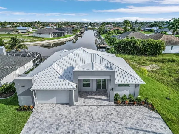 an aerial view of a house with a garden and lake view