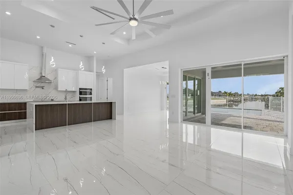 a large kitchen with a counter top space stainless steel appliances and a ceiling fan