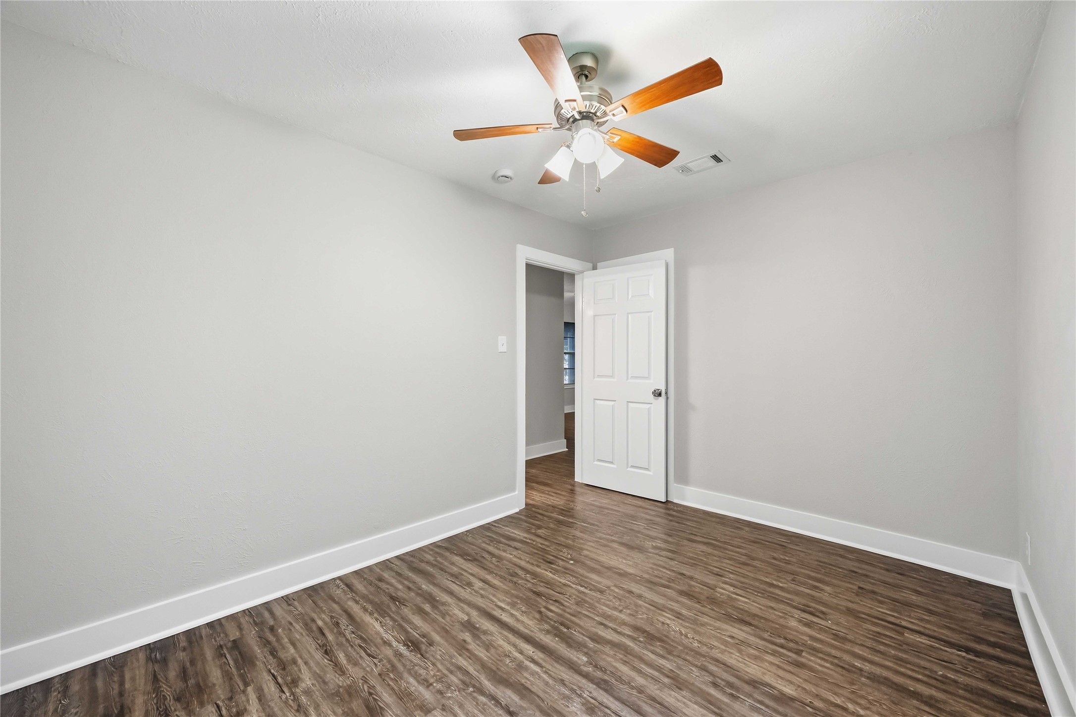 113 East Witcher Lane Houston, TX 77076 - Photo 20 of 21 an empty room with wooden floor and white walls