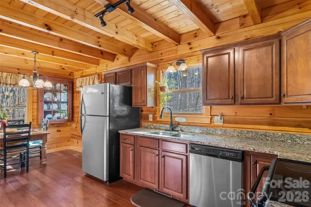 a kitchen with stainless steel appliances granite countertop a refrigerator and wooden cabinets