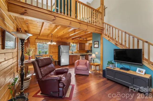 a living room with furniture a flat screen tv and a floor to ceiling window
