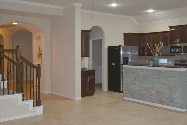 a large kitchen with kitchen island granite countertop a large window and a counter top space