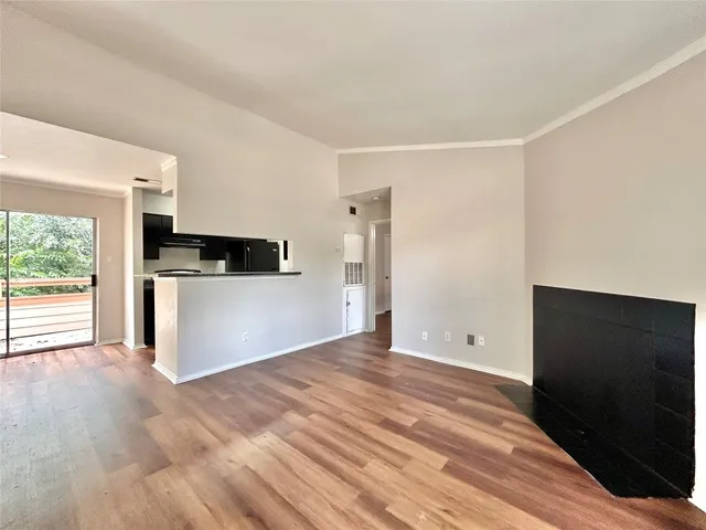 a view of a kitchen with wooden floor and a hallway