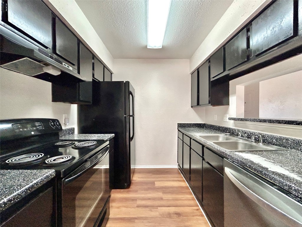 7111 East Highway 290, Unit C Austin, TX 78723 - Photo 7 of 20 a kitchen with a stove sink and refrigerator