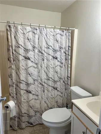 a white toilet sitting next to a shower curtain