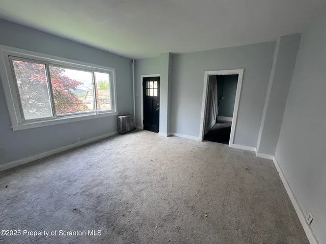 a view of a big room with windows and chandelier