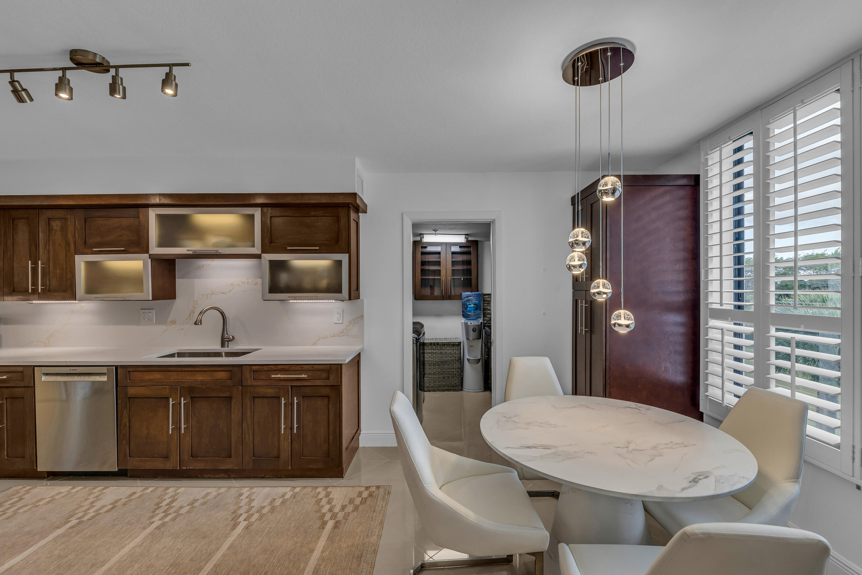 7572 Regency Lake Drive, Unit 402 Boca Raton, FL 33433 - Photo 15 of 31 a kitchen with a table chairs sink and refrigerator