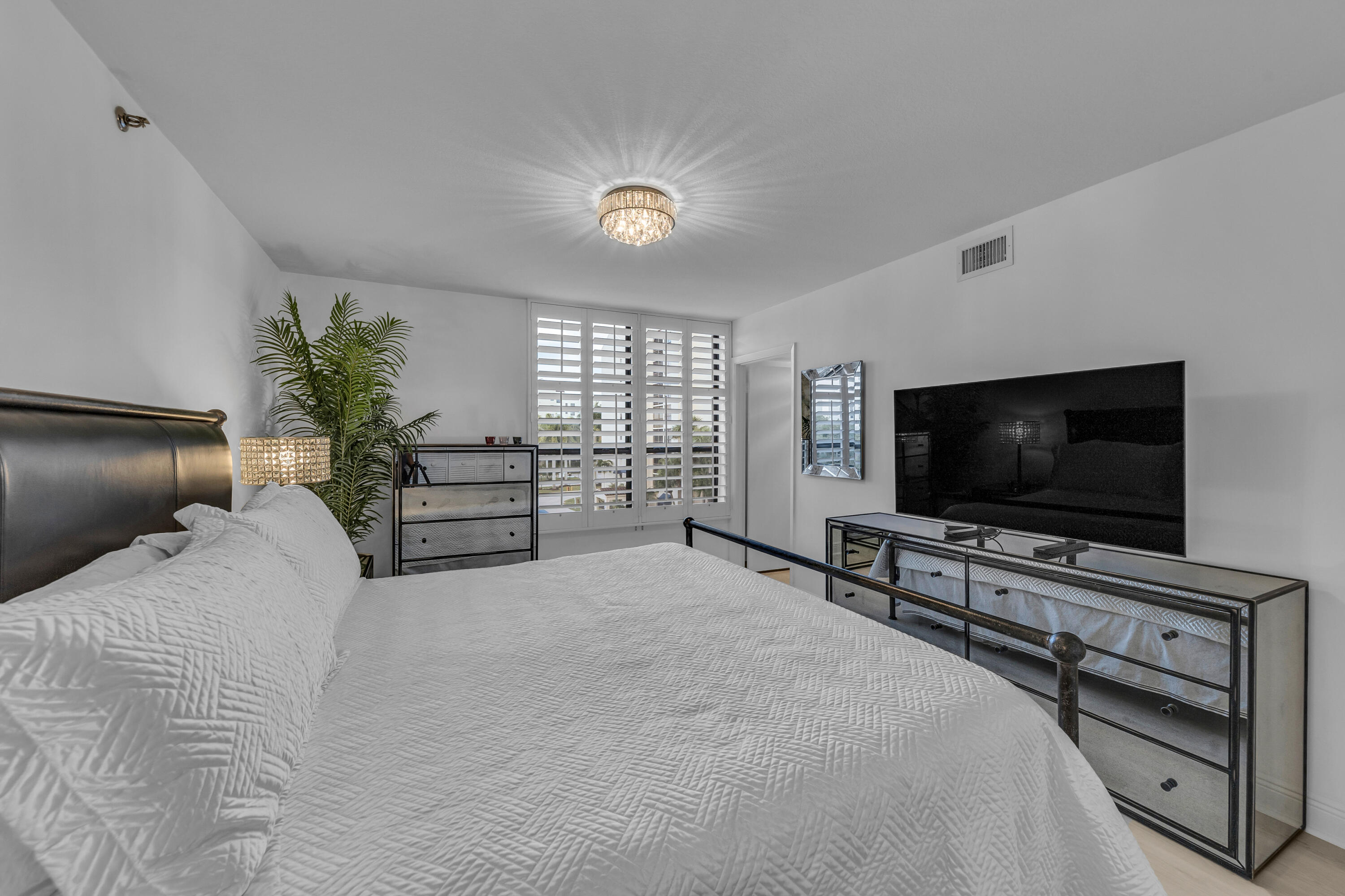 7572 Regency Lake Drive, Unit 402 Boca Raton, FL 33433 - Photo 25 of 31 a view of a livingroom with furniture and a flat screen tv