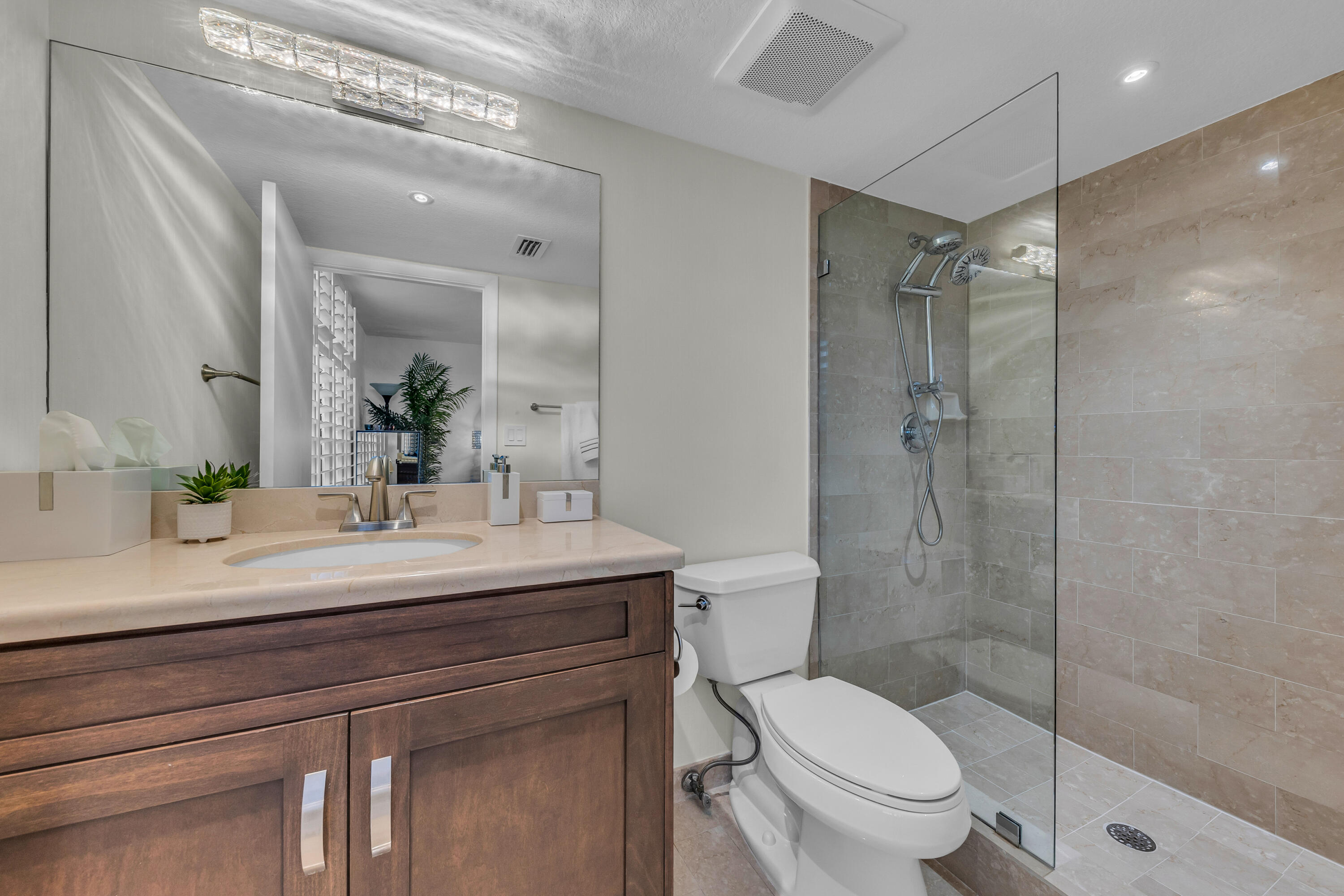7572 Regency Lake Drive, Unit 402 Boca Raton, FL 33433 - Photo 28 of 31 a bathroom with a sink a toilet and shower