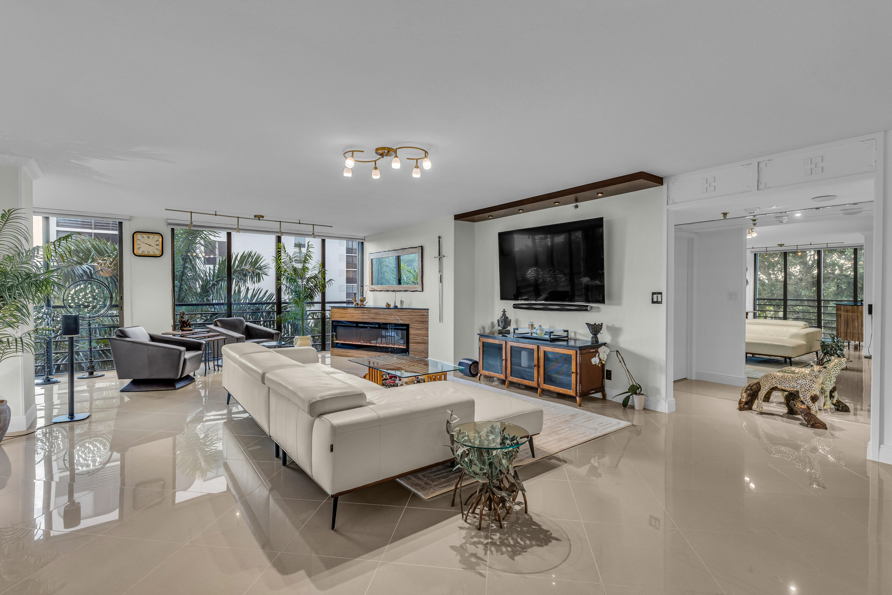7572 Regency Lake Drive, Unit 402 Boca Raton, FL 33433 - Photo 3 of 31 a living room with furniture and a flat screen tv