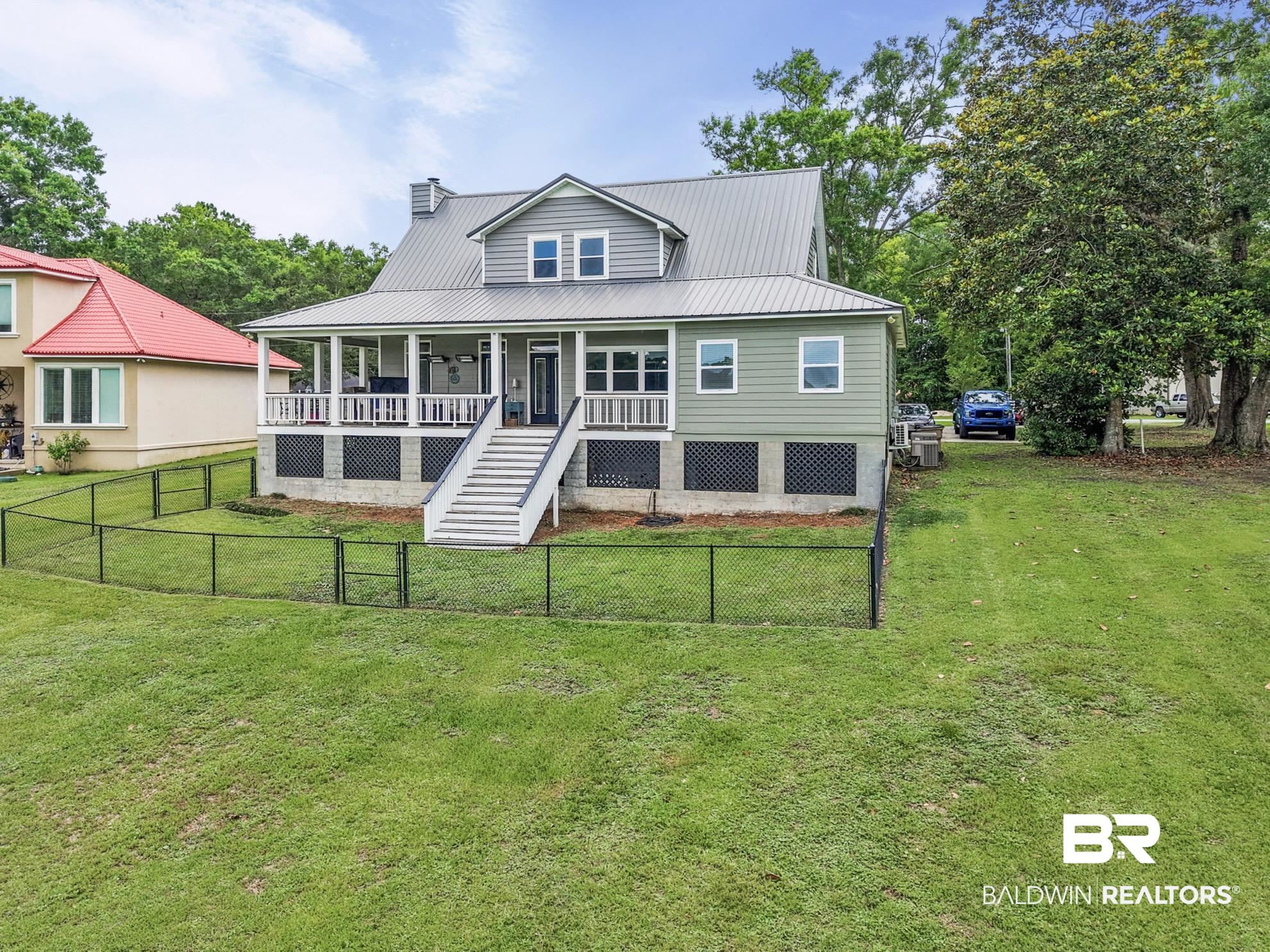 12171 Marguerite Drive Coden, AL 36523 - Photo 37 of 44 Raised home featuring a metal roof, dormer window, and a full-width covered porch with white railings