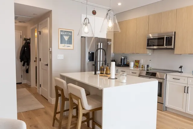 a kitchen with stainless steel appliances a stove a sink island and a refrigerator