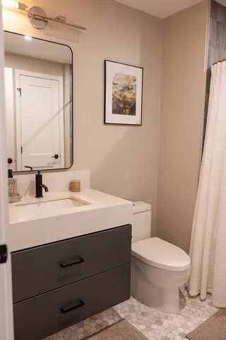 a bathroom with a toilet a sink and mirror