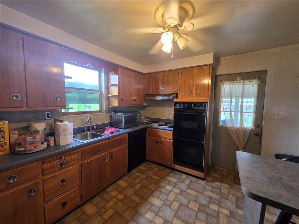 1356 Connellsville Road Lemont Furnace, PA 15456 - Photo 5 of 29 a kitchen with stainless steel appliances granite countertop a refrigerator a sink dishwasher a stove a dining table and chairs with wooden floor