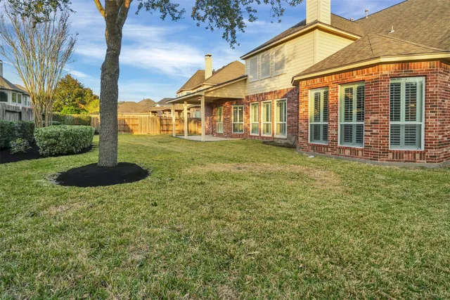 a view of a house with backyard and a tree