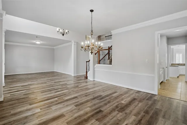 a view of a livingroom with a chandelier furniture and wooden floor