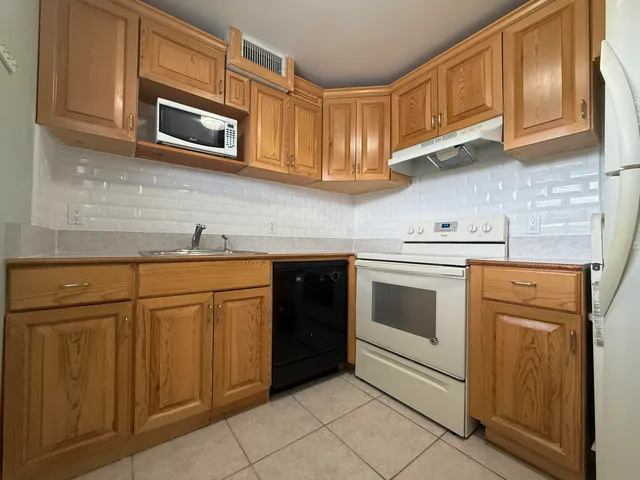 a kitchen with stainless steel appliances granite countertop white cabinets stove a sink and dishwasher