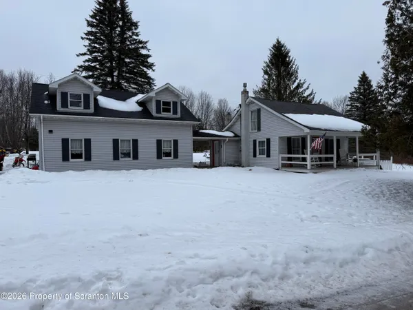 a view of a house with a yard and parking space