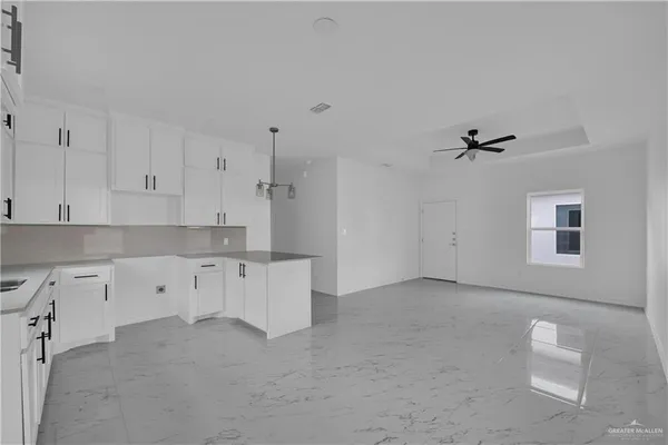 a kitchen with white cabinets and window