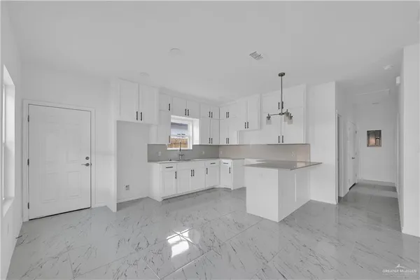 a large kitchen with cabinets and wooden floor