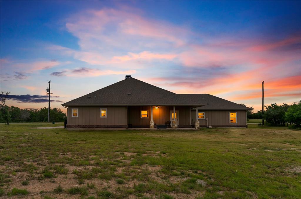 139 Kriston Lane Springtown, TX 76082 - Photo 30 of 39 Ranch-style exterior with a covered front porch featuring stone columns and a dark shingle roof