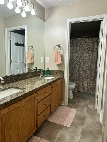 a spacious bathroom with a granite countertop sink and a mirror