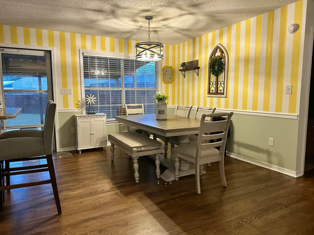 a dining room with wooden floor and a window