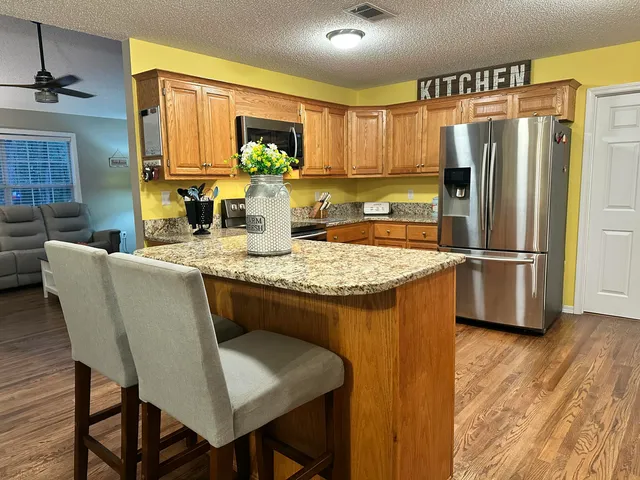a kitchen with stainless steel appliances granite countertop a sink refrigerator and microwave