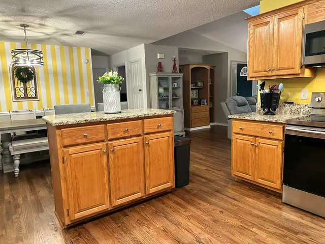 a kitchen with stainless steel appliances granite countertop a stove a sink and a refrigerator