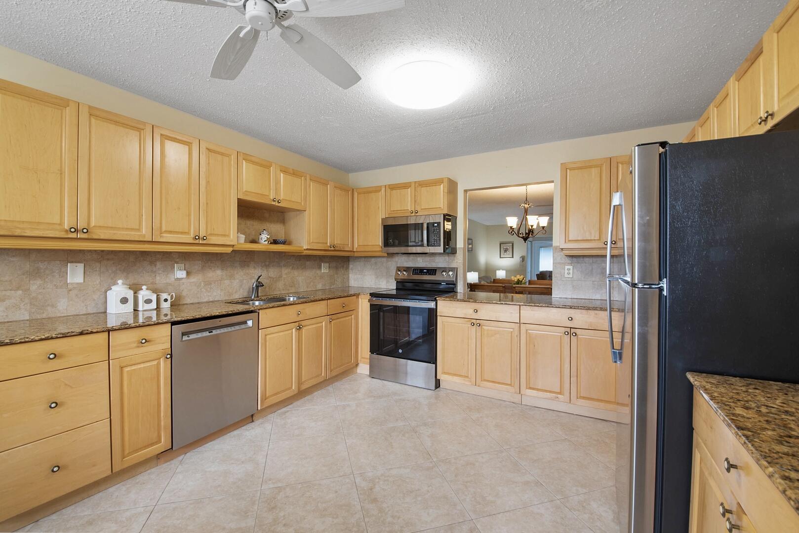 5222 Privet Place, Unit B Delray Beach, FL 33484 - Photo 10 of 27 a kitchen with granite countertop white cabinets and stainless steel appliances