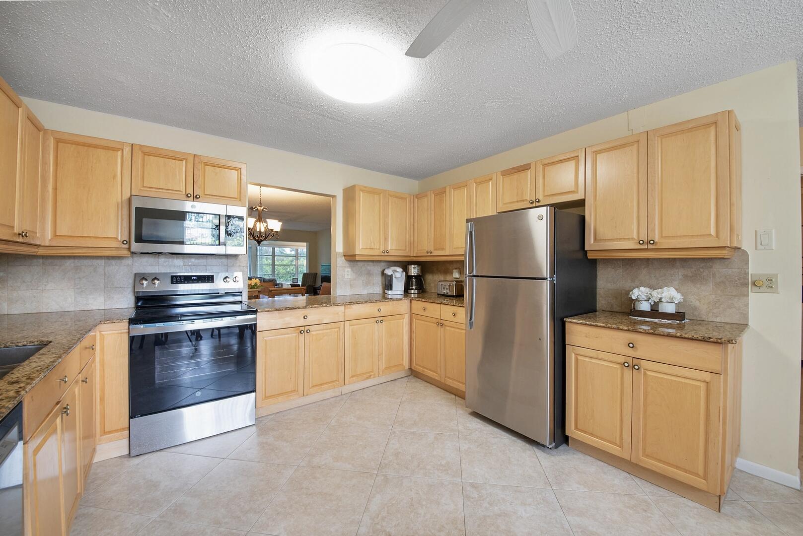 5222 Privet Place, Unit B Delray Beach, FL 33484 - Photo 11 of 27 a kitchen with a refrigerator and a stove top oven