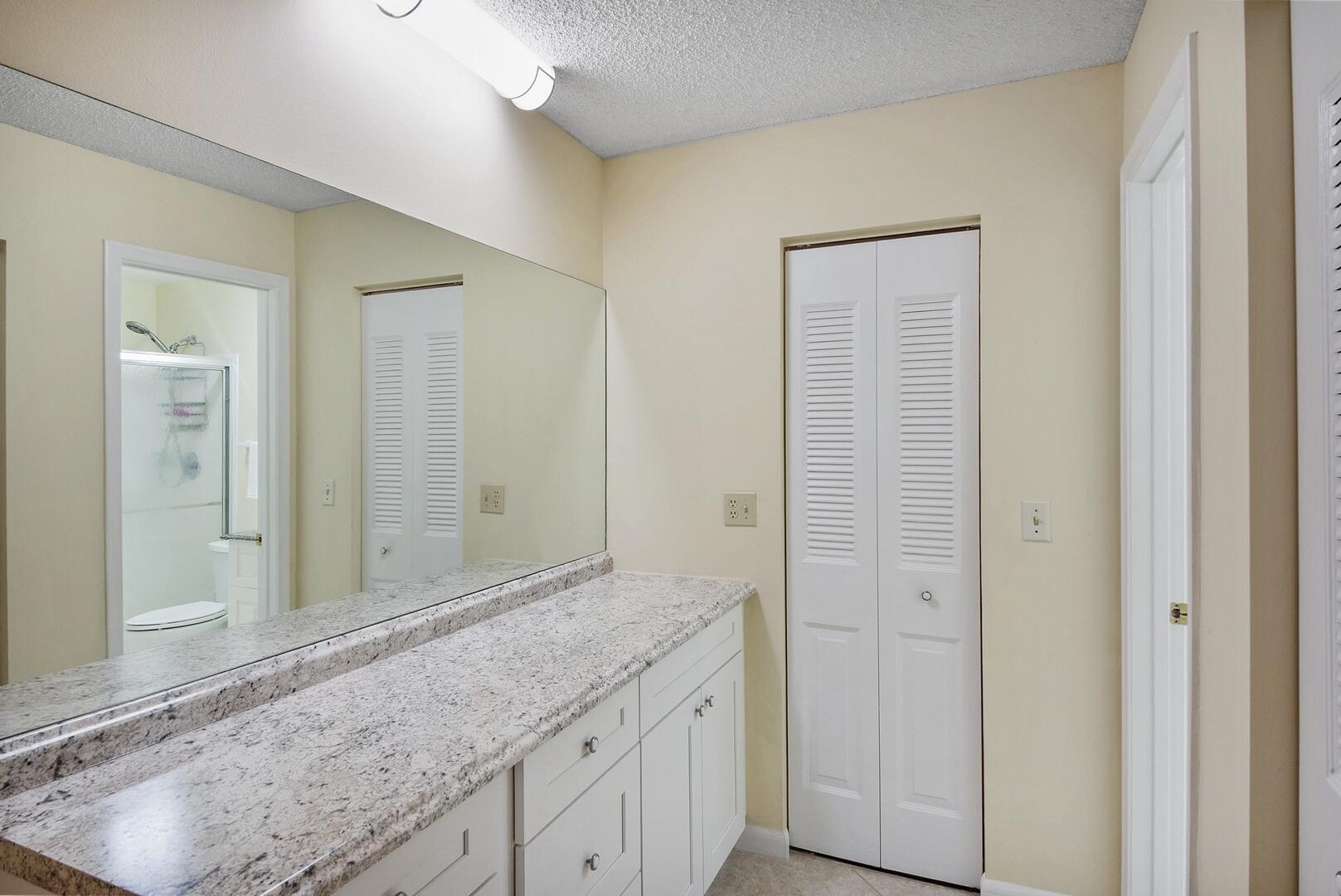 5222 Privet Place, Unit B Delray Beach, FL 33484 - Photo 17 of 27 a bathroom with a granite countertop sink and a mirror