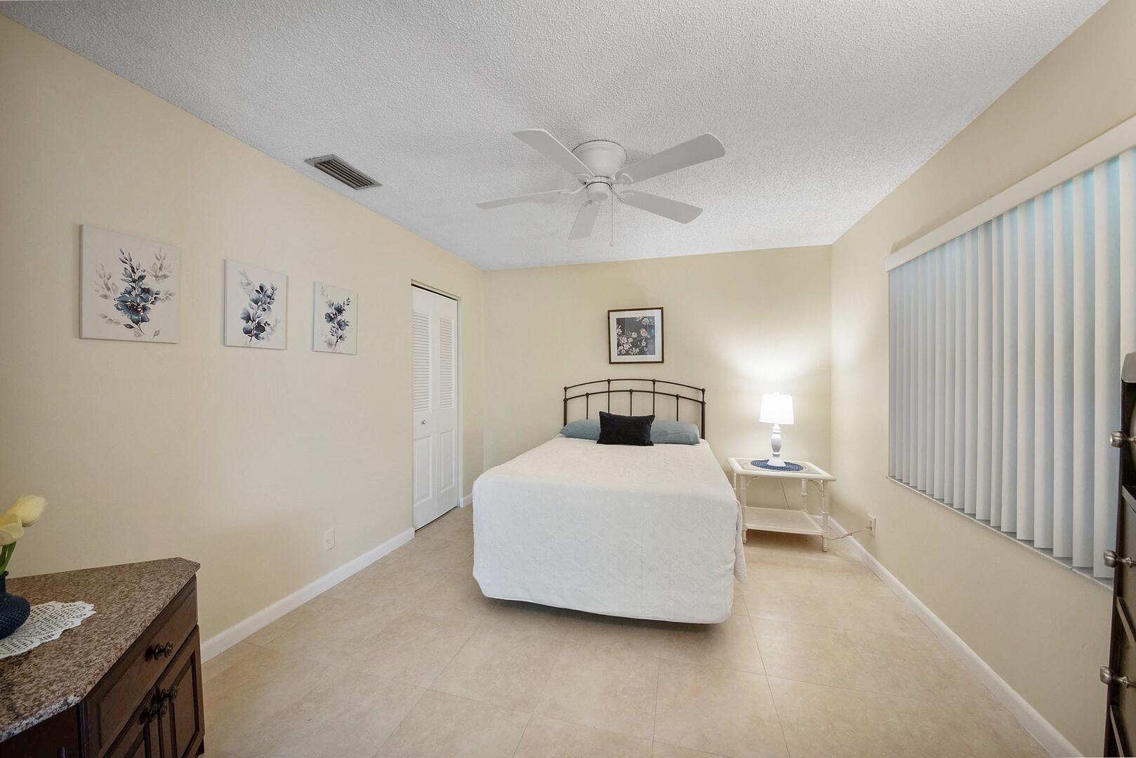 5222 Privet Place, Unit B Delray Beach, FL 33484 - Photo 19 of 27 a bedroom with a bed and a chandelier