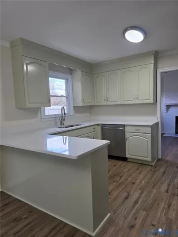 a kitchen with kitchen island granite countertop a sink cabinets and wooden floor